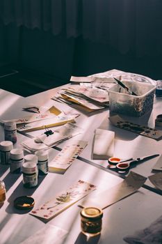 A sunlit table filled with various art supplies for creative projects.