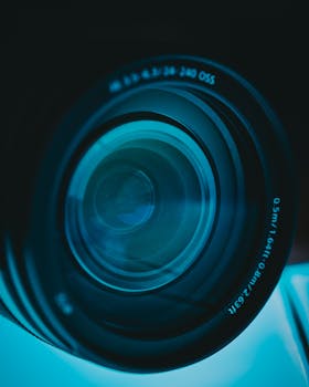 相机镜头的特写展示了其复杂的设计和蓝色色调，非常适合科技主题