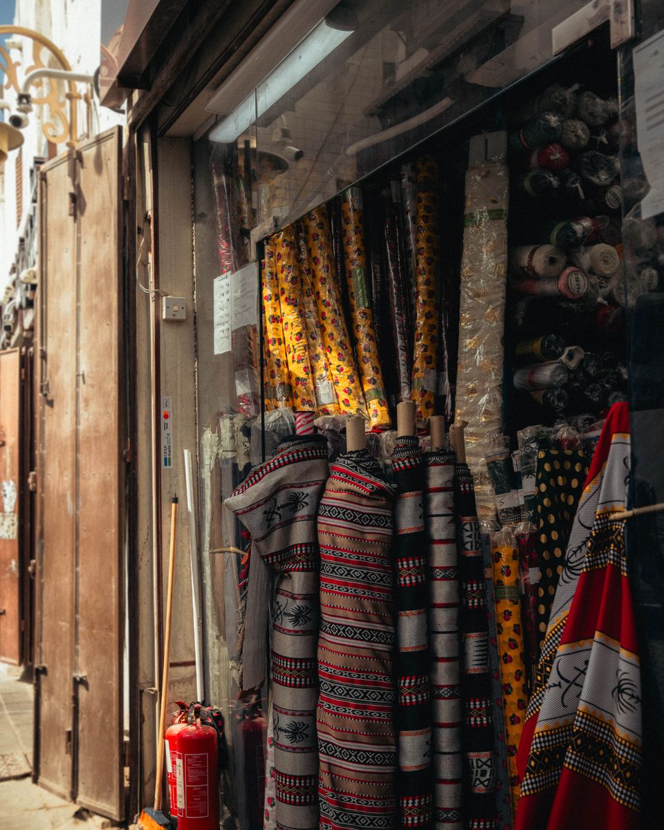 Colorful fabric and goods displayed at a vibrant market stall