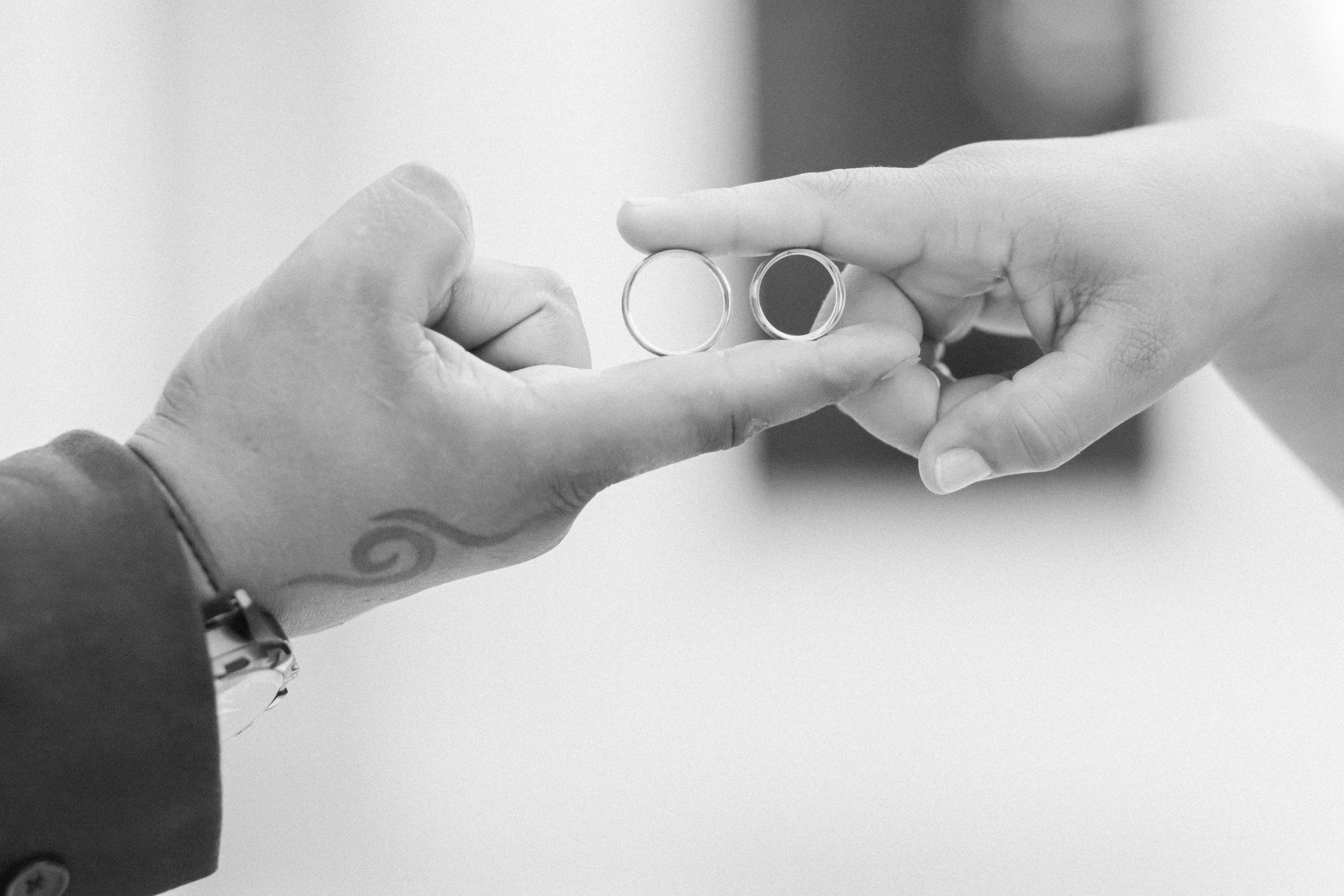 Close-Up of Hands Holding Wedding Rings · Free Stock Photo