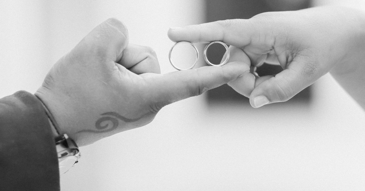 Close-Up of Hands Holding Wedding Rings · Free Stock Photo
