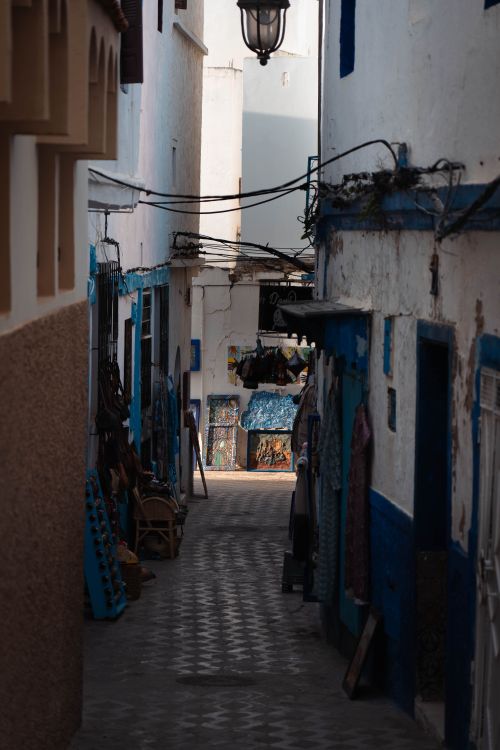 Free A picturesque narrow street lined with traditional Moroccan architecture in Asilah. Perfect for travel enthusiasts. Stock Photo