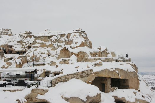 Snowy landscape of historic caves in Ürgüp, Nevşehir, Türkiye during winter.