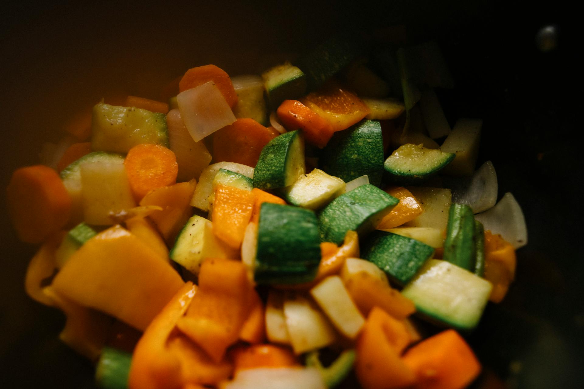 Close-up of sliced vegetables including zucchini, carrots, and peppers for a colorful and healthy dish.