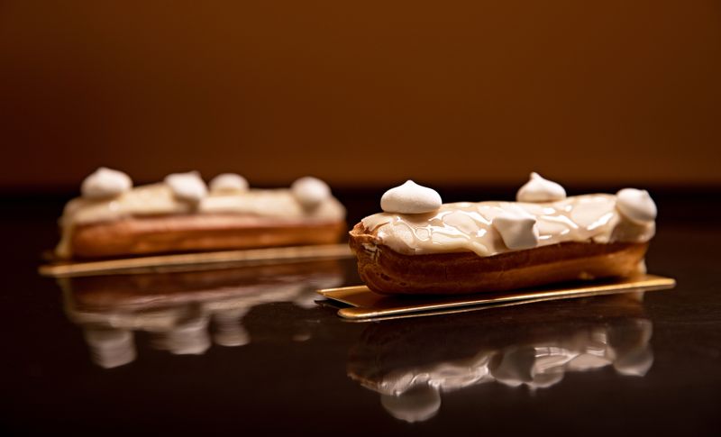 Eclairs with icing arranged on trays.