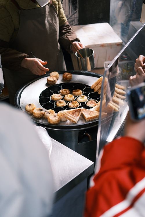 Free Street vendor prepares delicious pastries in an urban setting. Stock Photo
