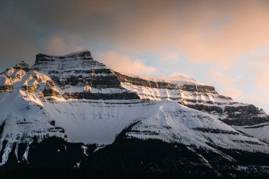 A breathtaking view of a snow-covered mountain at sunset in Banff, Alberta, Canada.