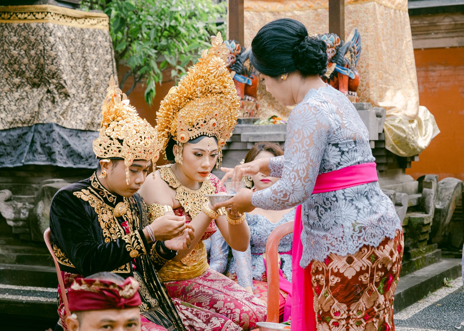A vibrant Balinese ceremony featuring traditional attire and rituals, outdoors.