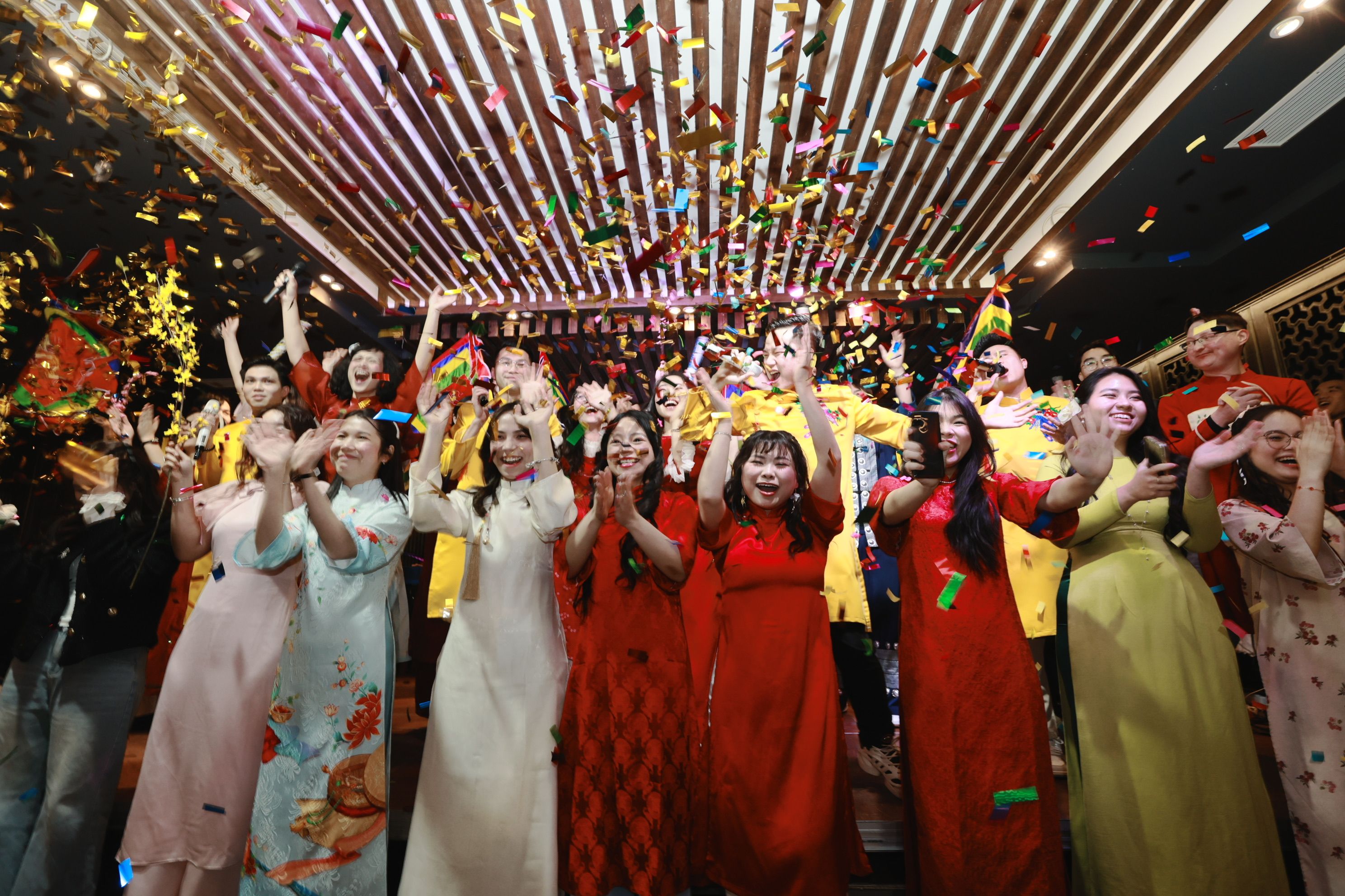A lively indoor celebration with people in traditional attire and colorful confetti in Berlin, Germany.