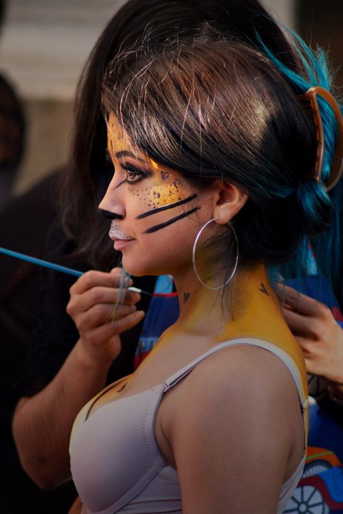Free Young woman with creative face paint being prepared for a cultural celebration in Puebla, Mexico. Stock Photo