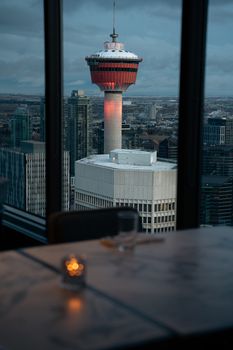 A beautiful view of the Calgary Tower seen through a restaurant window during dusk.