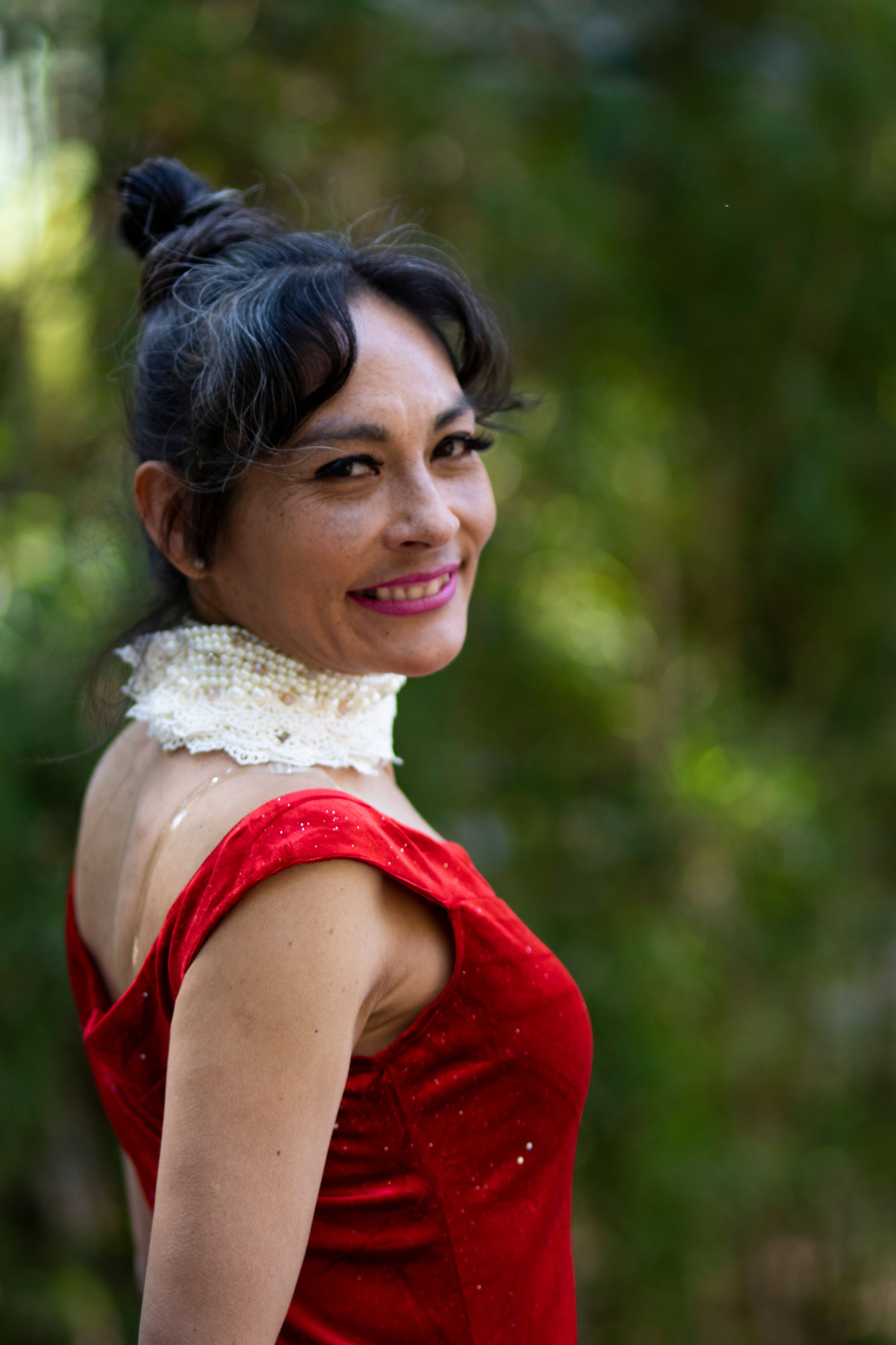 Elegant Woman in Red Dress Smiling Outdoors · Free Stock Photo