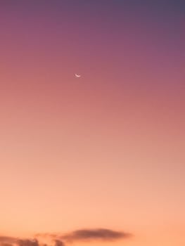 暮色渐染，宁静的天空中，一轮精致的新月悬于柔和的色彩渐变之上