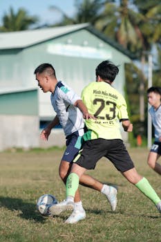 Intense soccer match between young players outdoors on a sunny day.