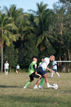 Action shot of a soccer match with players competing in a lush tropical field.