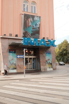 Street view of an IMAX cinema with 'Joker' poster and urban elements.