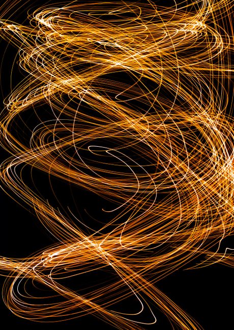 Vibrant abstract image featuring swirling golden light trails against a dark backdrop.