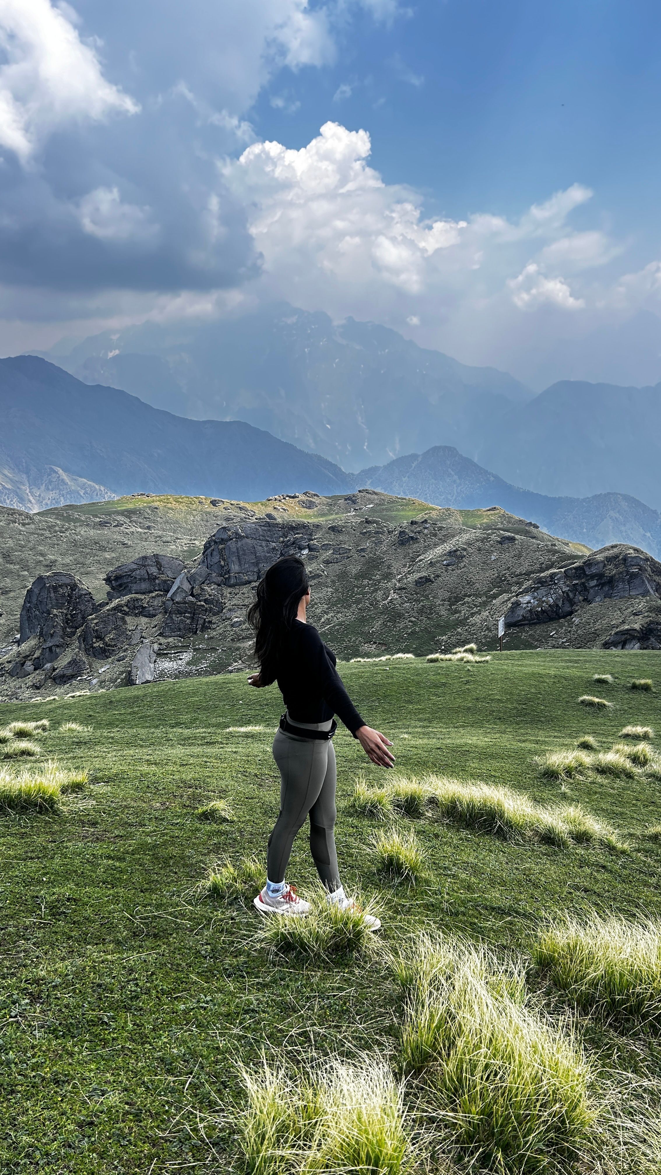 Ücretsiz Hindistan'ın Uttarakhand eyaletine bağlı Sobala RF'de yemyeşil dağlar ve bulutlu gökyüzüyle çevrili bir alanda yürüyüş yapan kadın. Stok Fotoğraflar