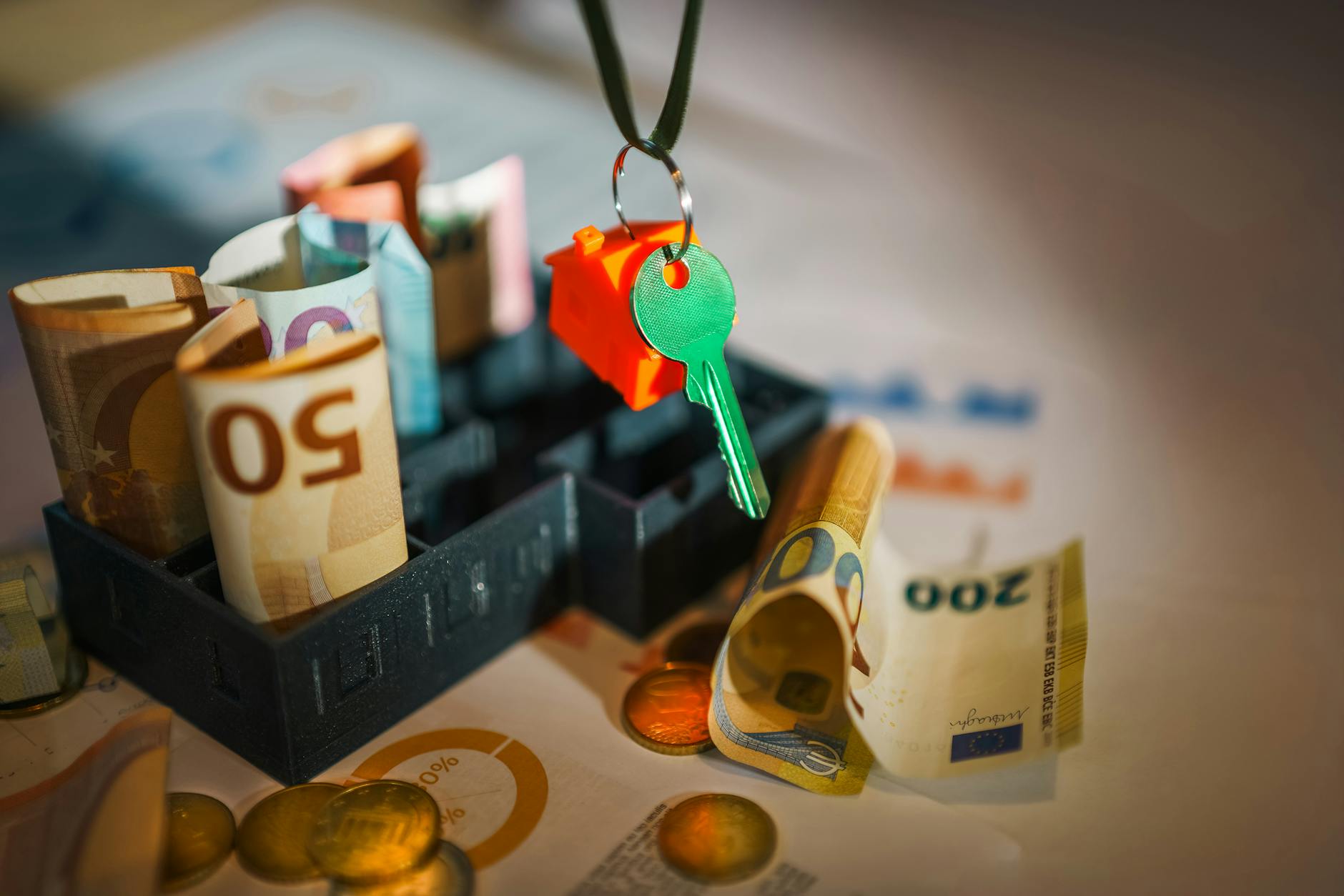 House key and euro bills depicting real estate and financial themes.