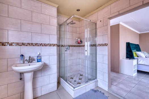 Bright and airy bathroom with a glass shower enclosure and a pedestal sink, featuring contemporary interior design.
