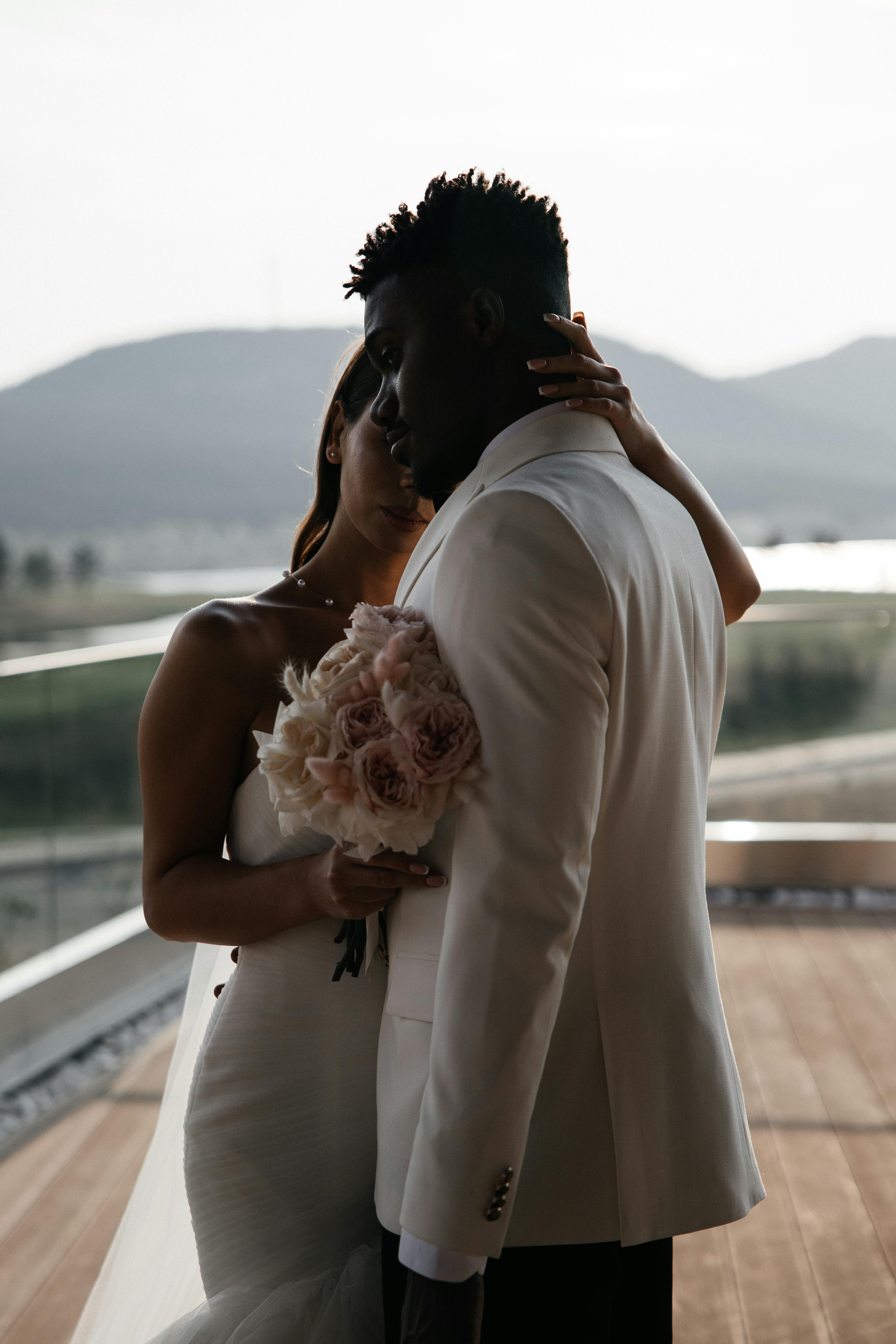 Bride and groom embrace in a serene outdoor wedding setting.
