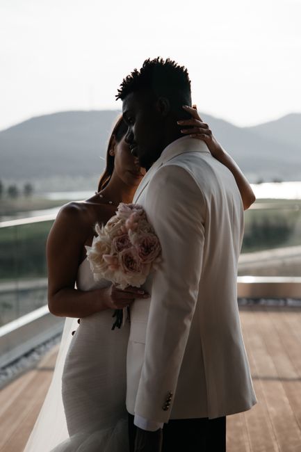 Bride and groom embrace in a serene outdoor wedding setting.