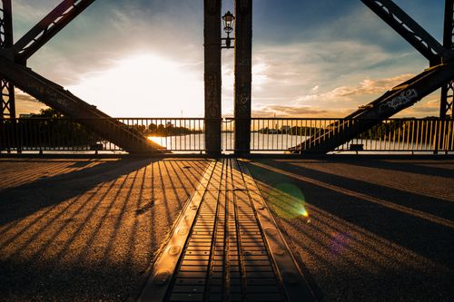 Free Striking sunset view through a railroad bridge in Hamburg, casting long shadows. Stock Photo