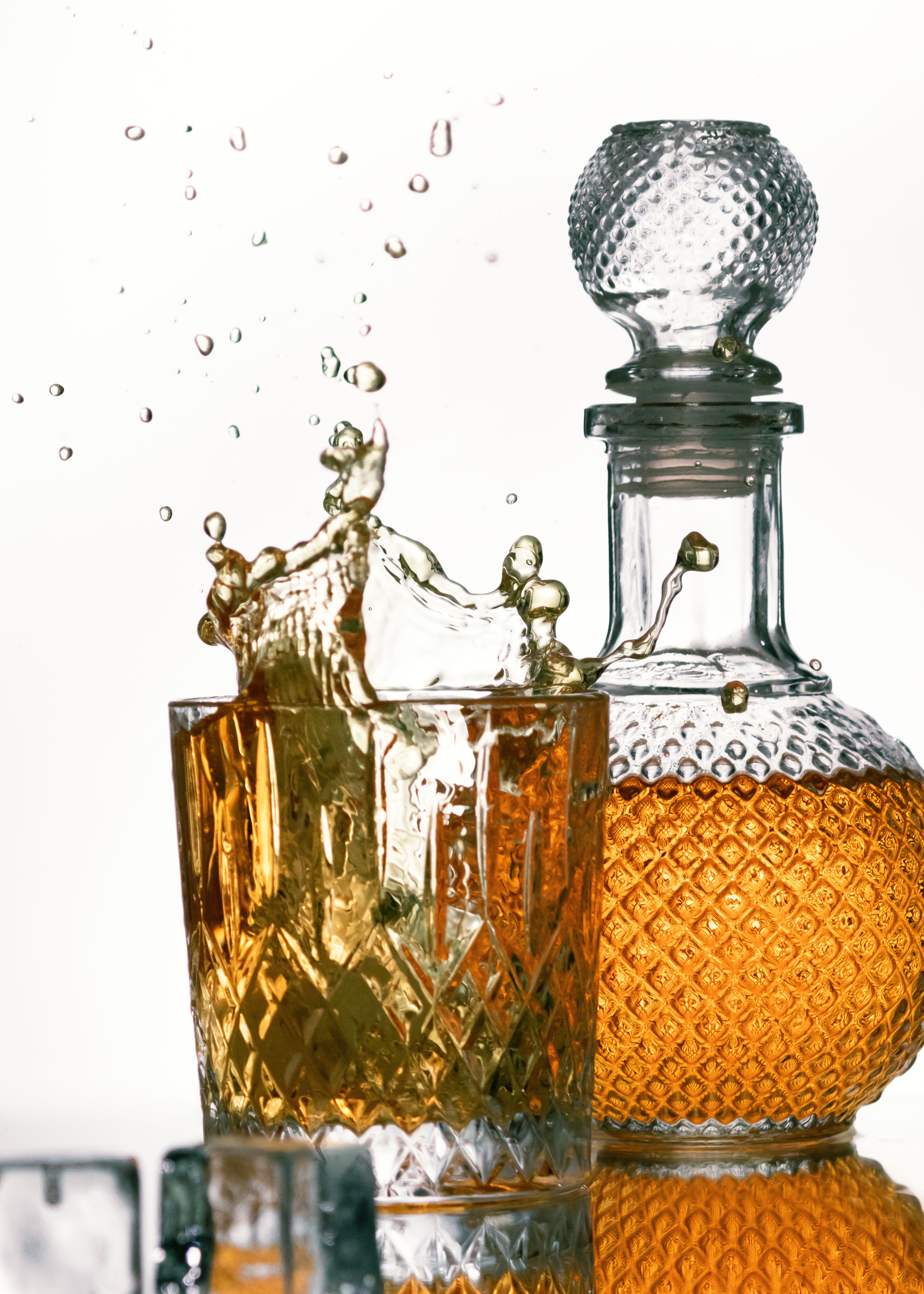 Een betoverende afbeelding van whisky die in een kristallen glas spettert, met een gedetailleerde karaf op de achtergrond.