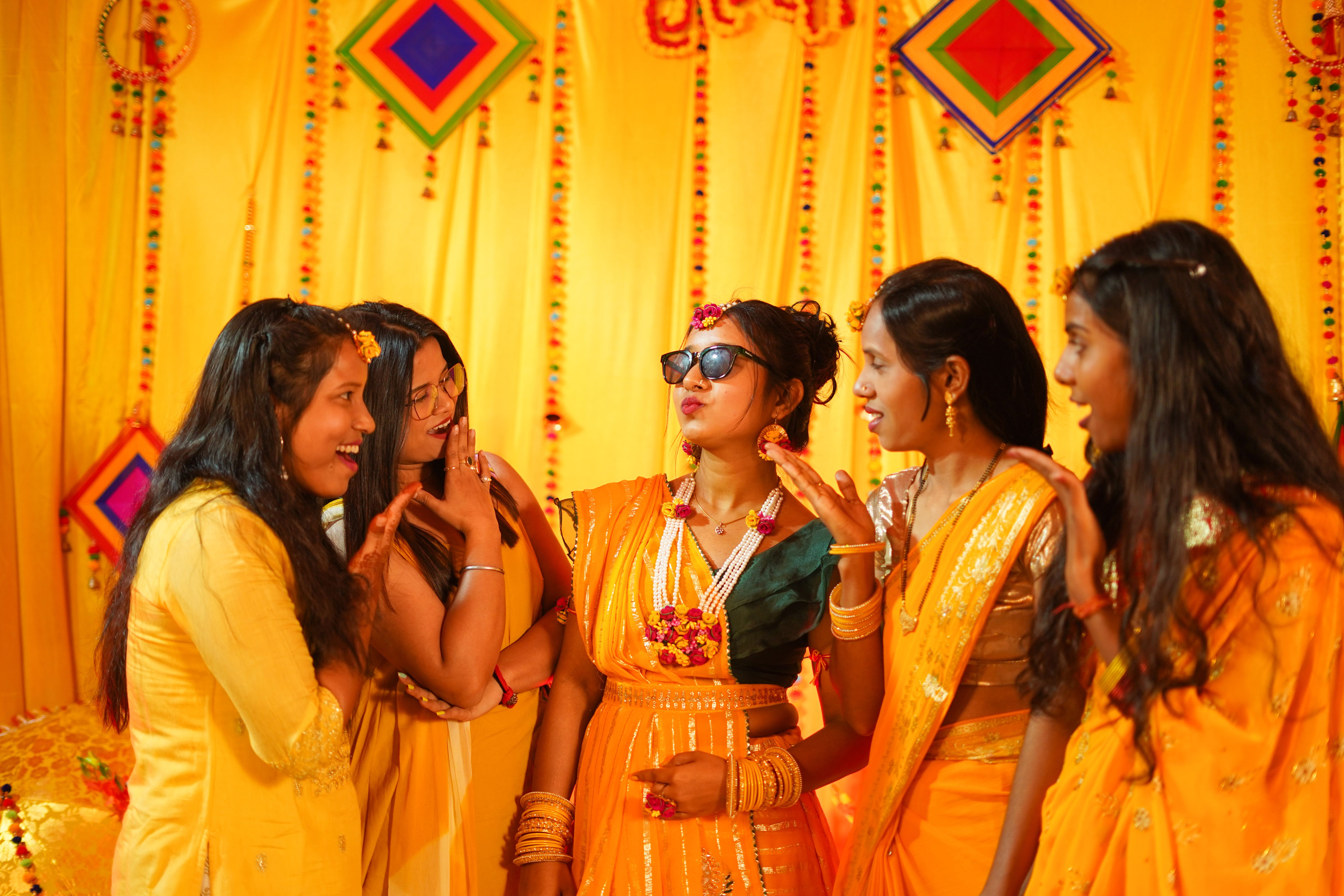 A vibrant Haldi ceremony with Indian bride and friends in traditional attire in Varanasi.