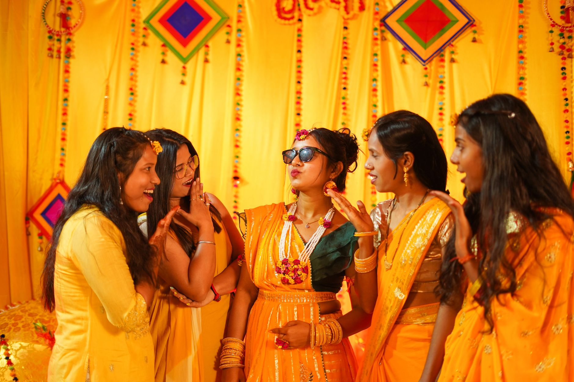A vibrant Haldi ceremony with Indian bride and friends in traditional attire in Varanasi.