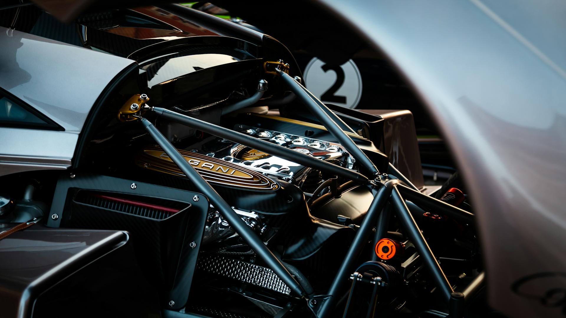 Close-up shot of a Pagani supercar engine with intricate mechanical details highlighted.