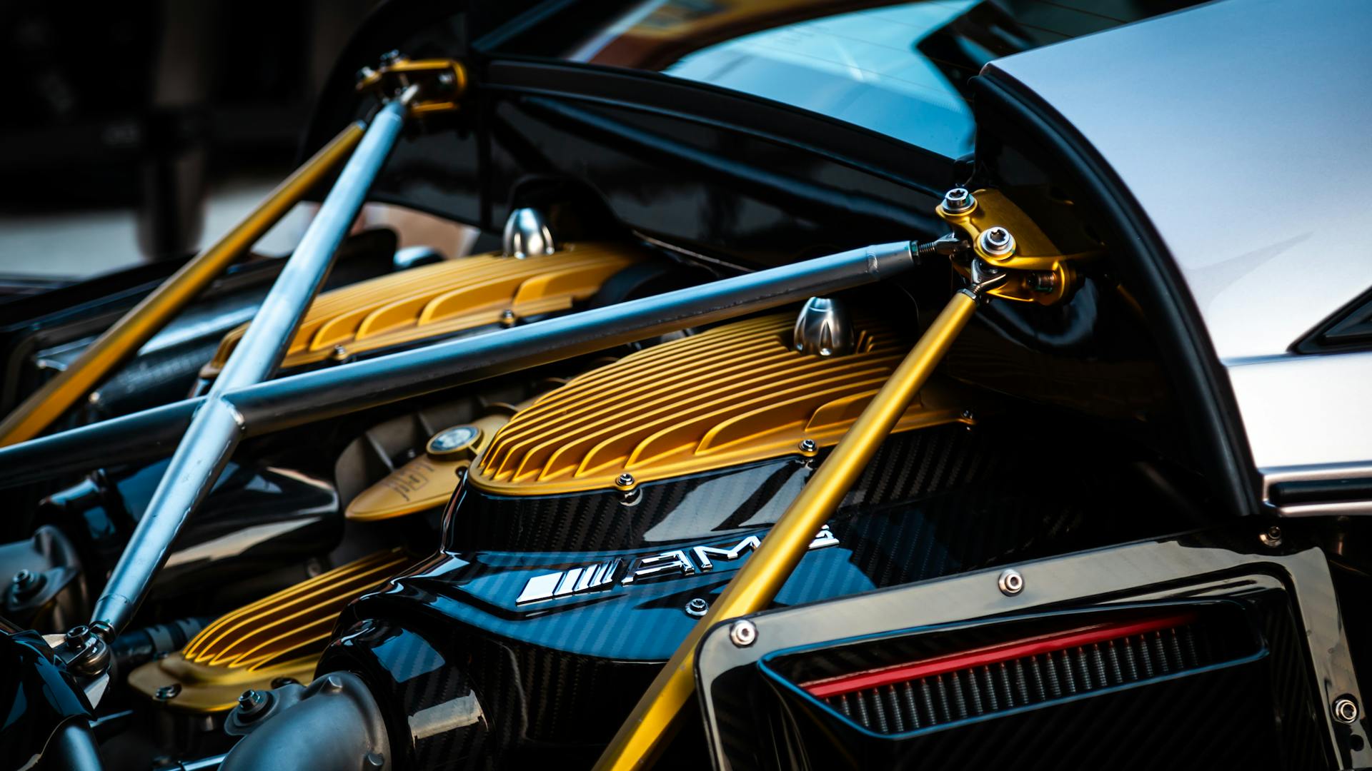 Detailed view of a luxury hypercar engine with gold and carbon fiber elements.