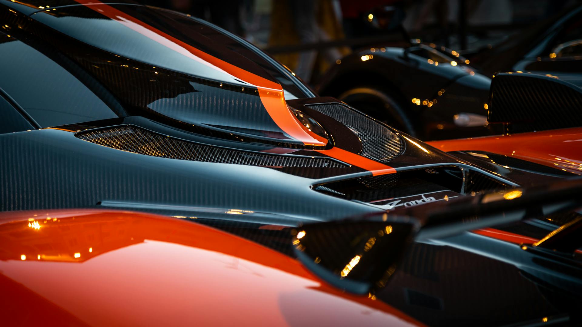 Detailed image of a Pagani supercar highlighting its aerodynamic design with carbon fiber elements.