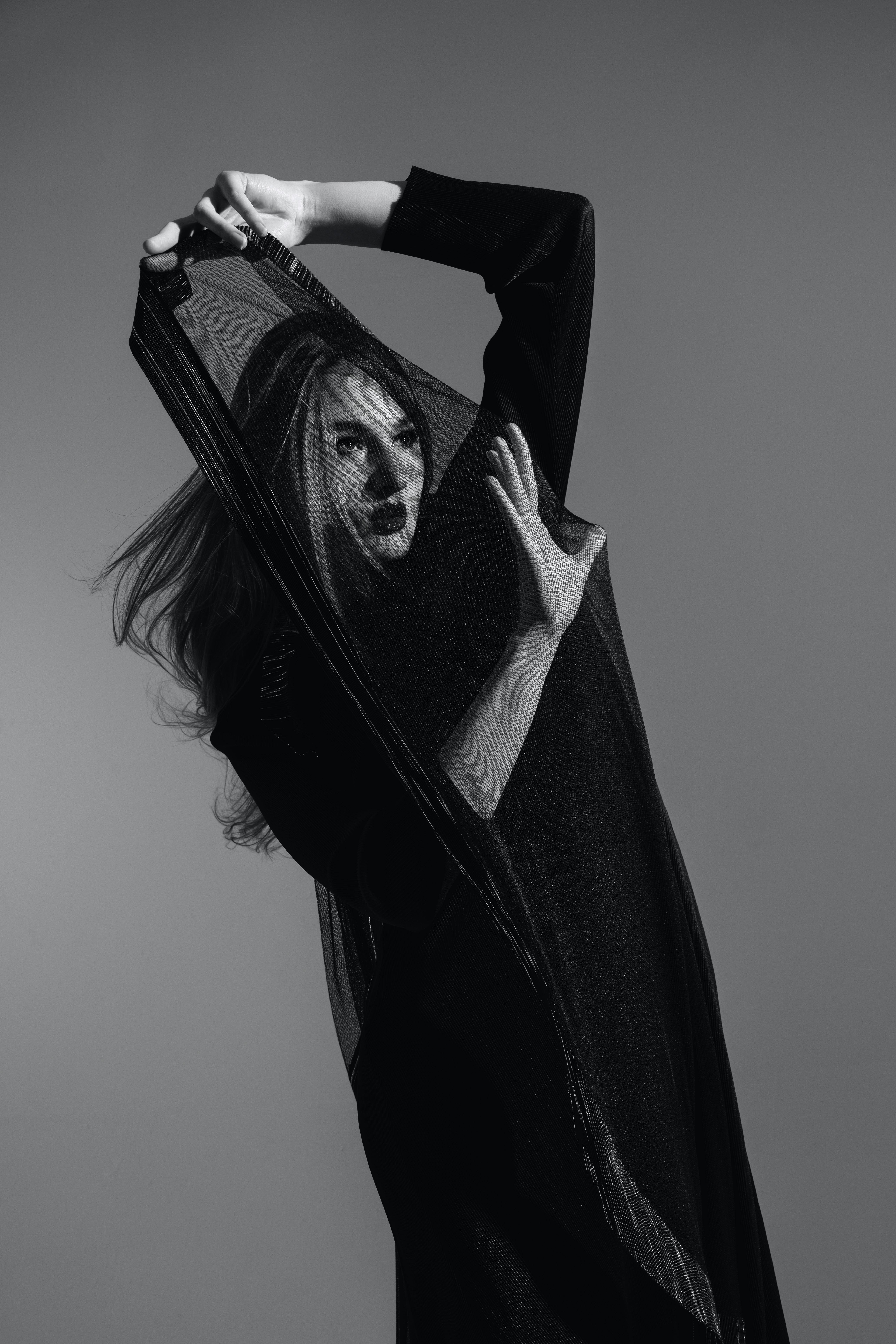 A striking black and white fashion portrait of a model in a black dress, exuding elegance and sophistication.