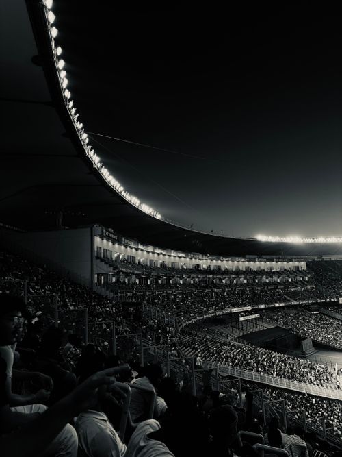 Free A high-contrast, monochrome image capturing a filled stadium during a night event. Stock Photo