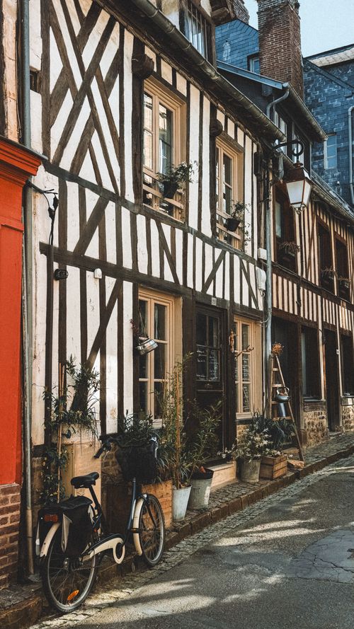 Free Historic half-timbered house with a bicycle on a quaint street. Perfect for travel and architecture themes. Stock Photo