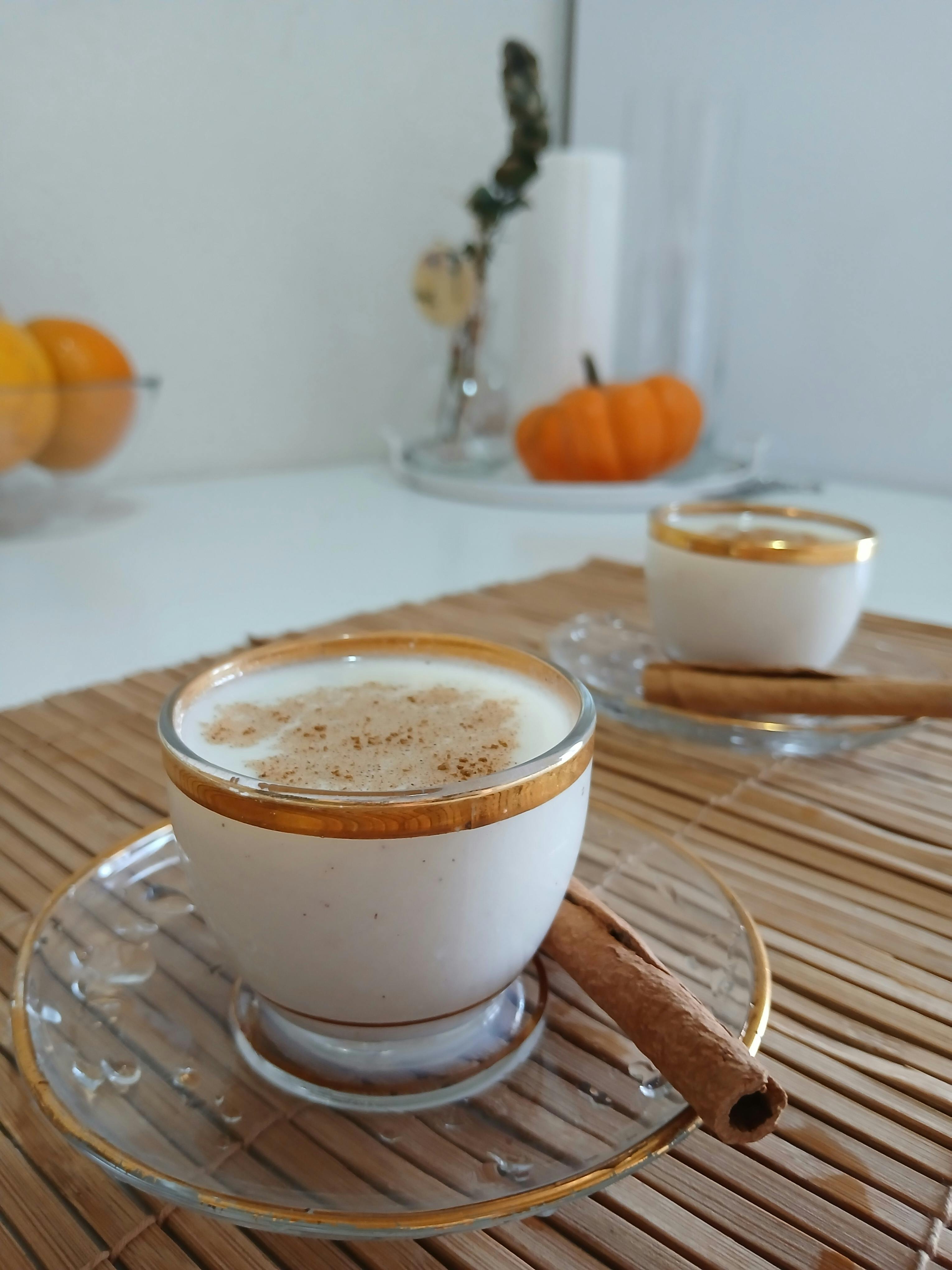 Warm coffee with cinnamon sticks on table, perfect for autumn vibes.