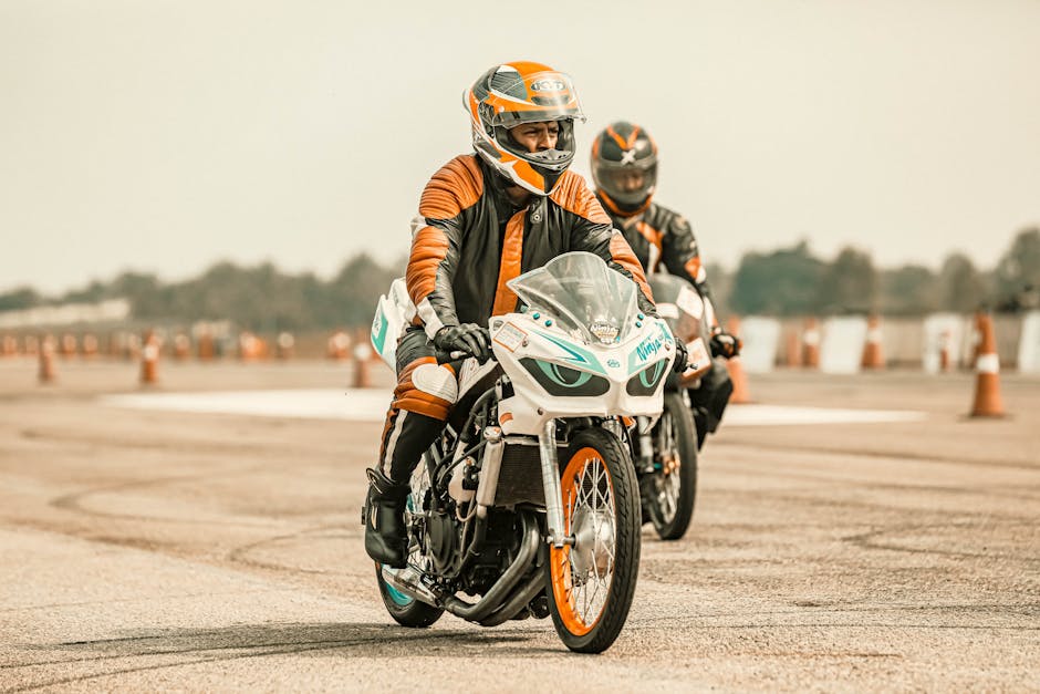Motorcyclists riding on a track in protective gear, showcasing speed and skill.