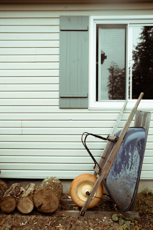 Blue and Brown Wheelbarrow Near Window