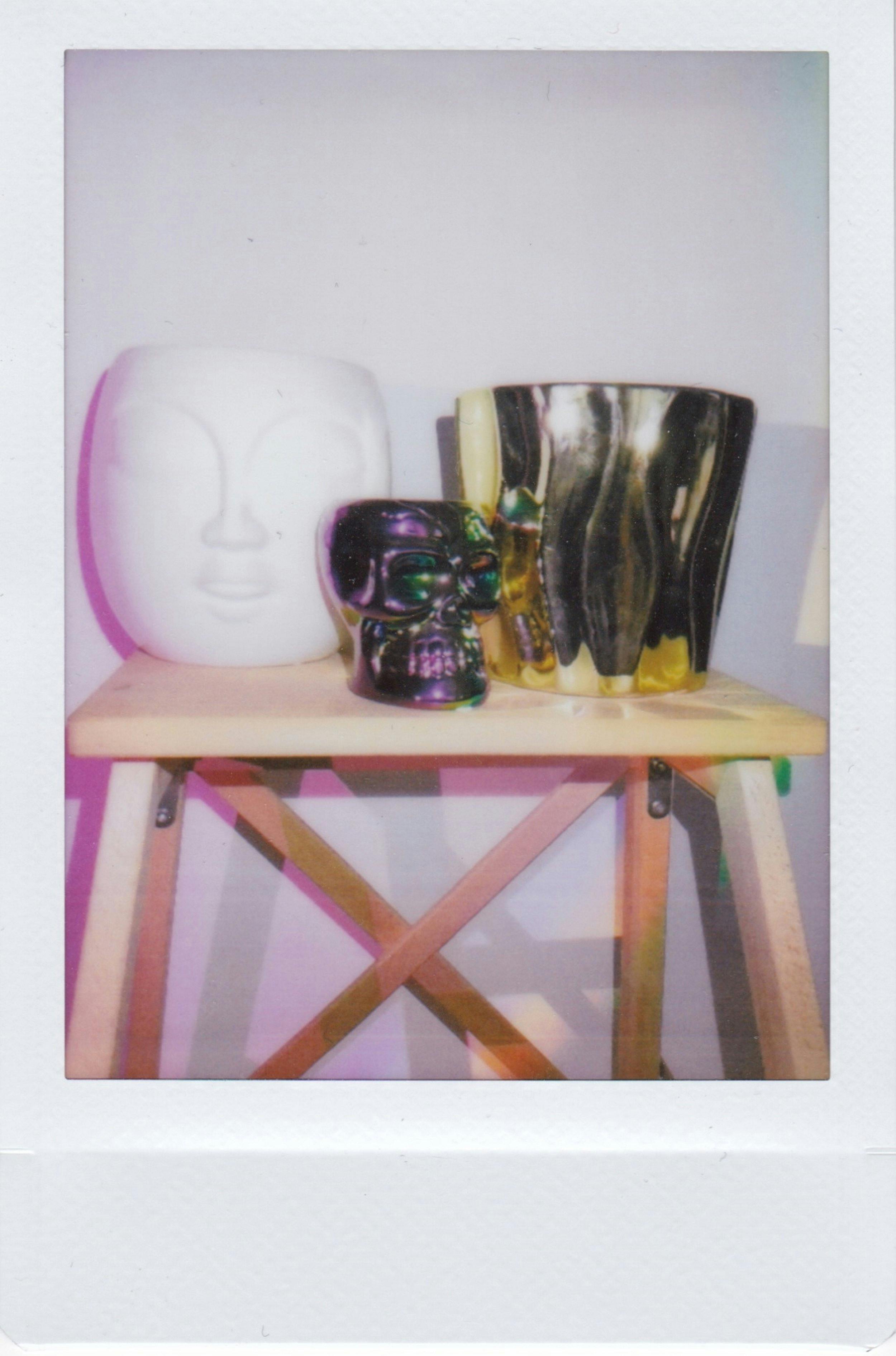 Artistic arrangement of skull and vase on a wooden stool captures a unique aesthetic.