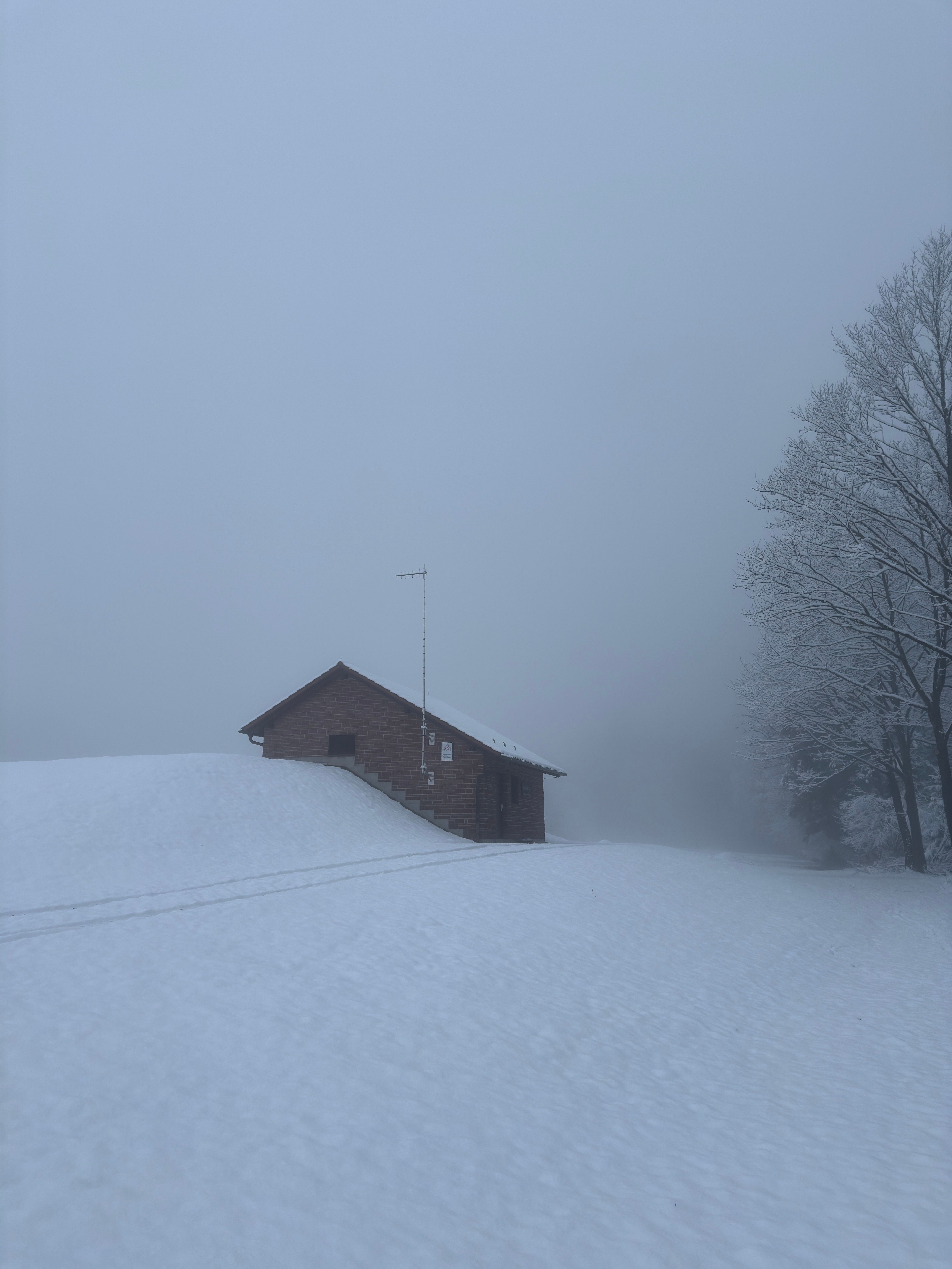 Wooden cabin in snow and fog, by Eddson Lens on Pexels