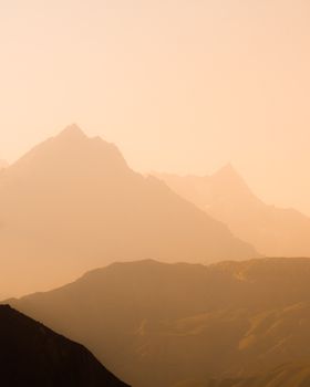Peaceful mountain range bathed in soft golden light, perfect for nature or travel themes.