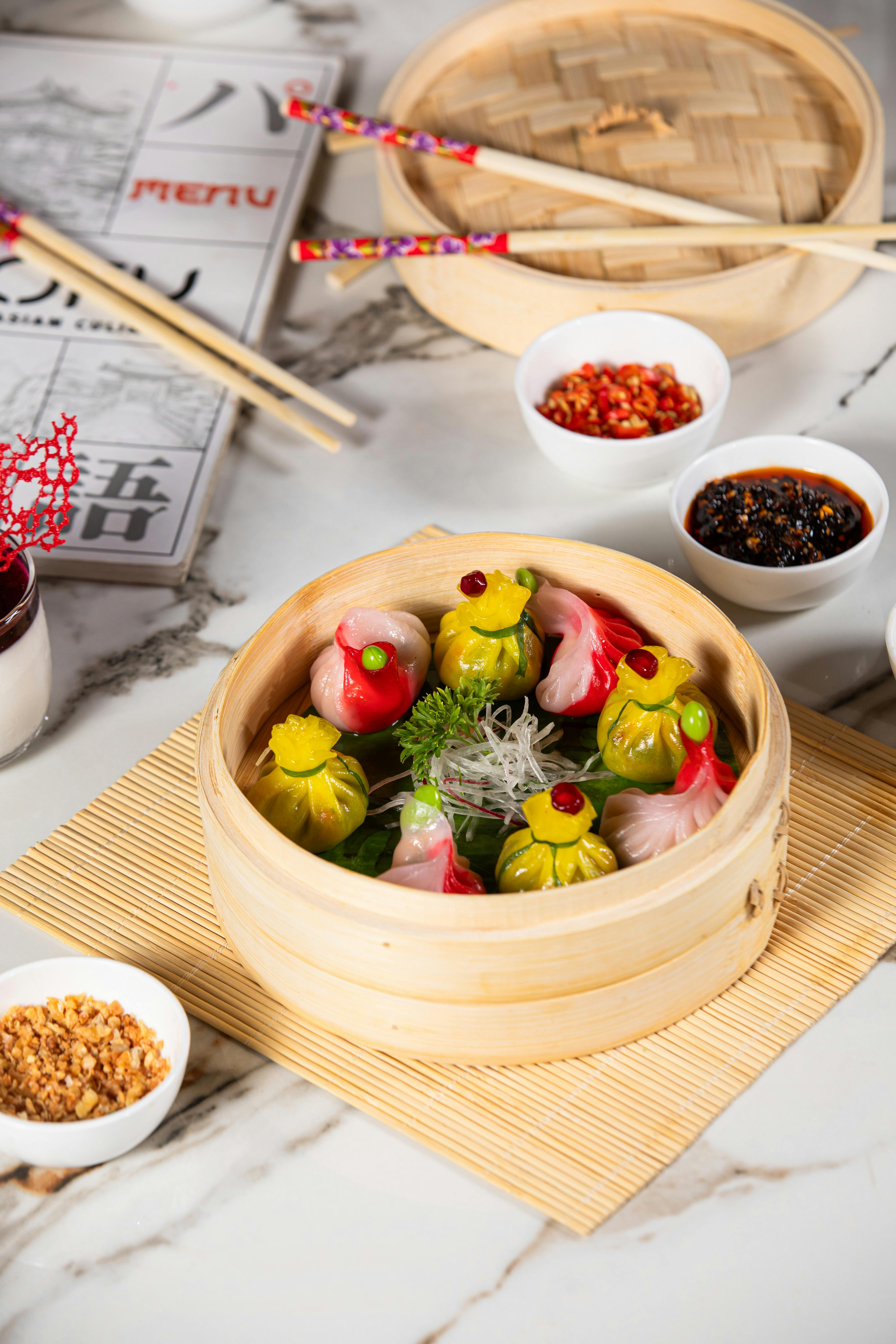 colorful dim sum in bamboo steamer with chopsticks