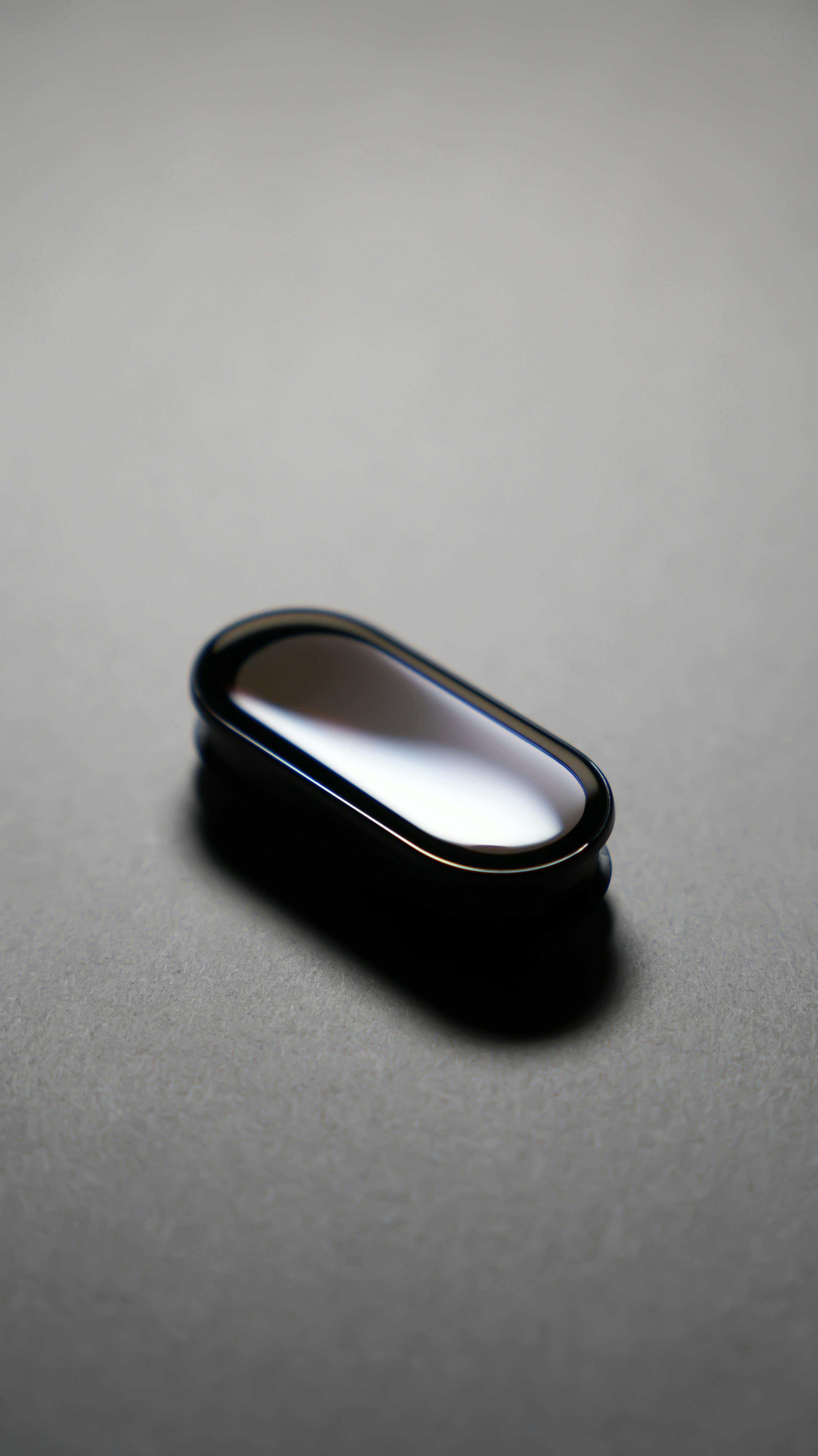 ingyenes Minimalista, elegáns technológiai eszköz sötét háttérrel, modern dizájnesztétikát bemutató. Stockfotó