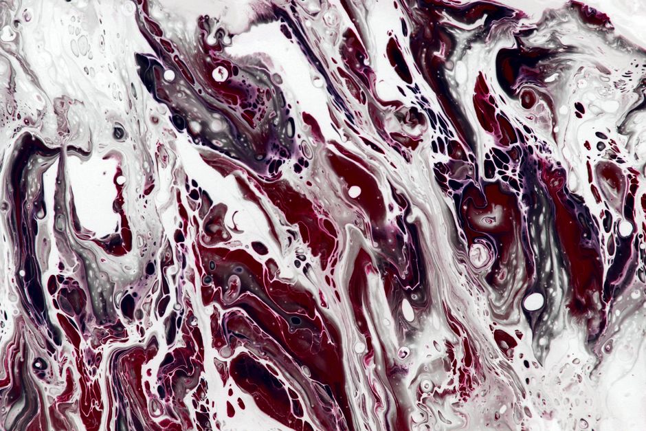 Vivid abstract fluid art featuring red and white swirling patterns creating a dynamic visual texture.