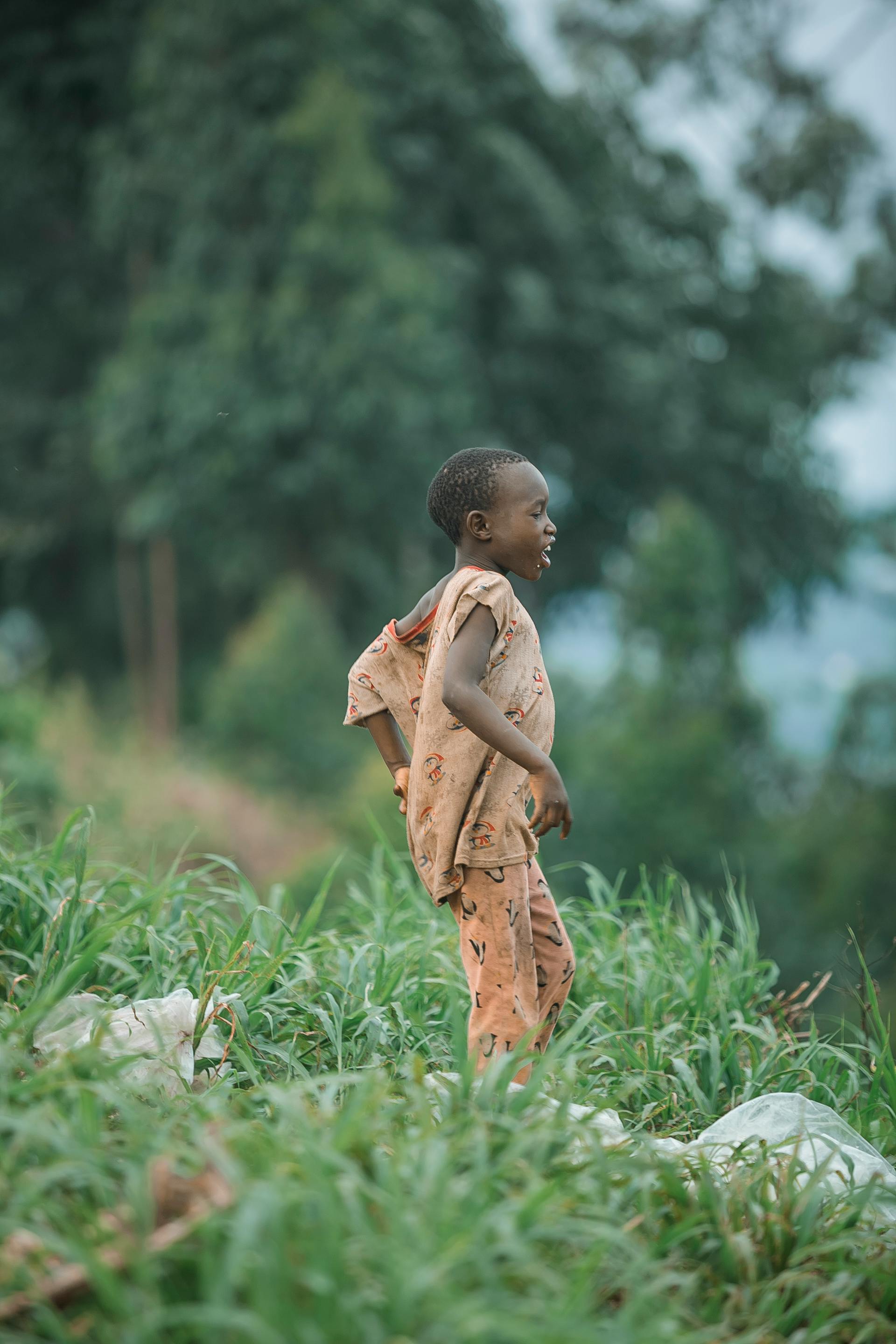 young child walking in lush greenery outdoors