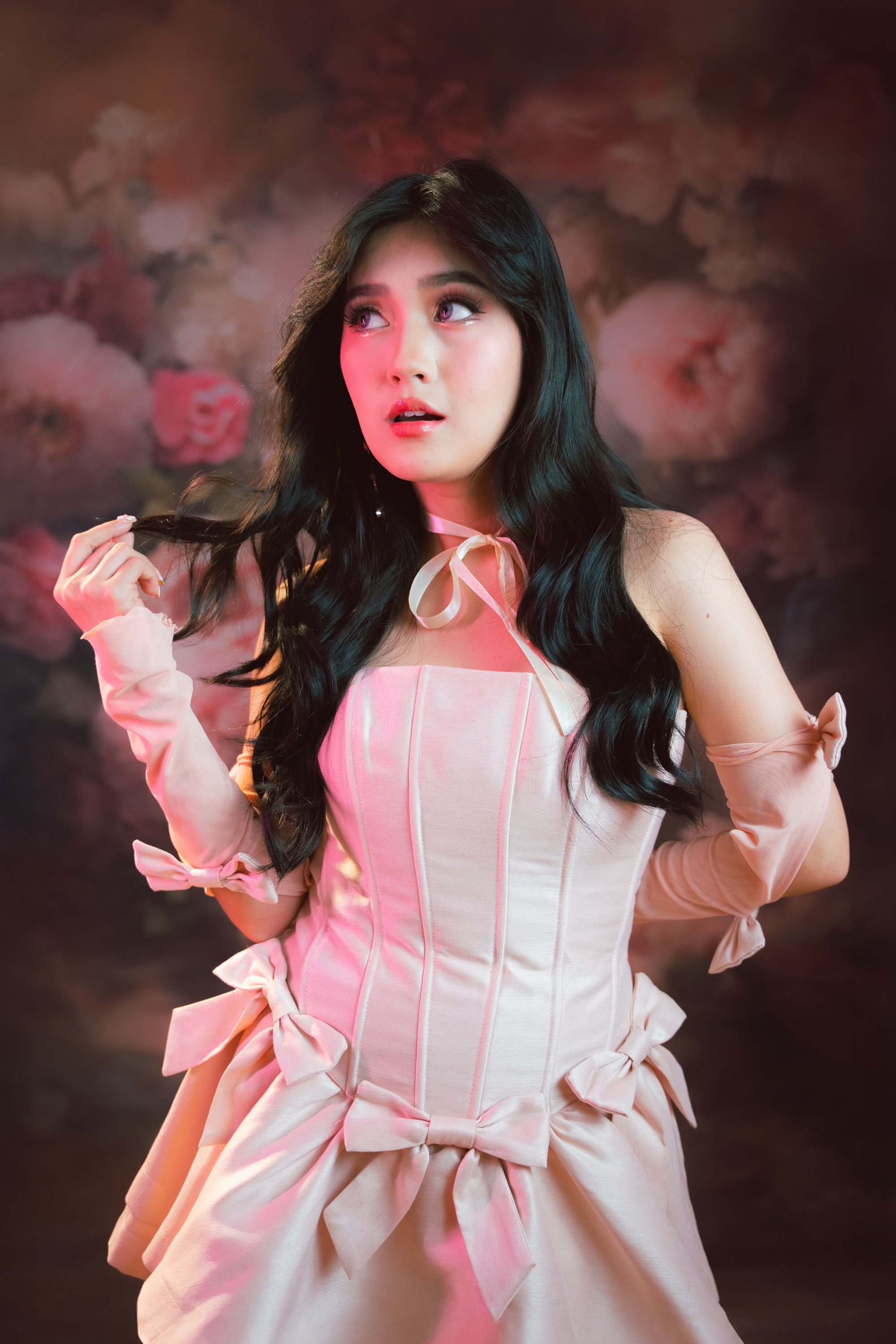 Elegant Woman in Vintage Pink Dress with Floral Backdrop · Free Stock Photo