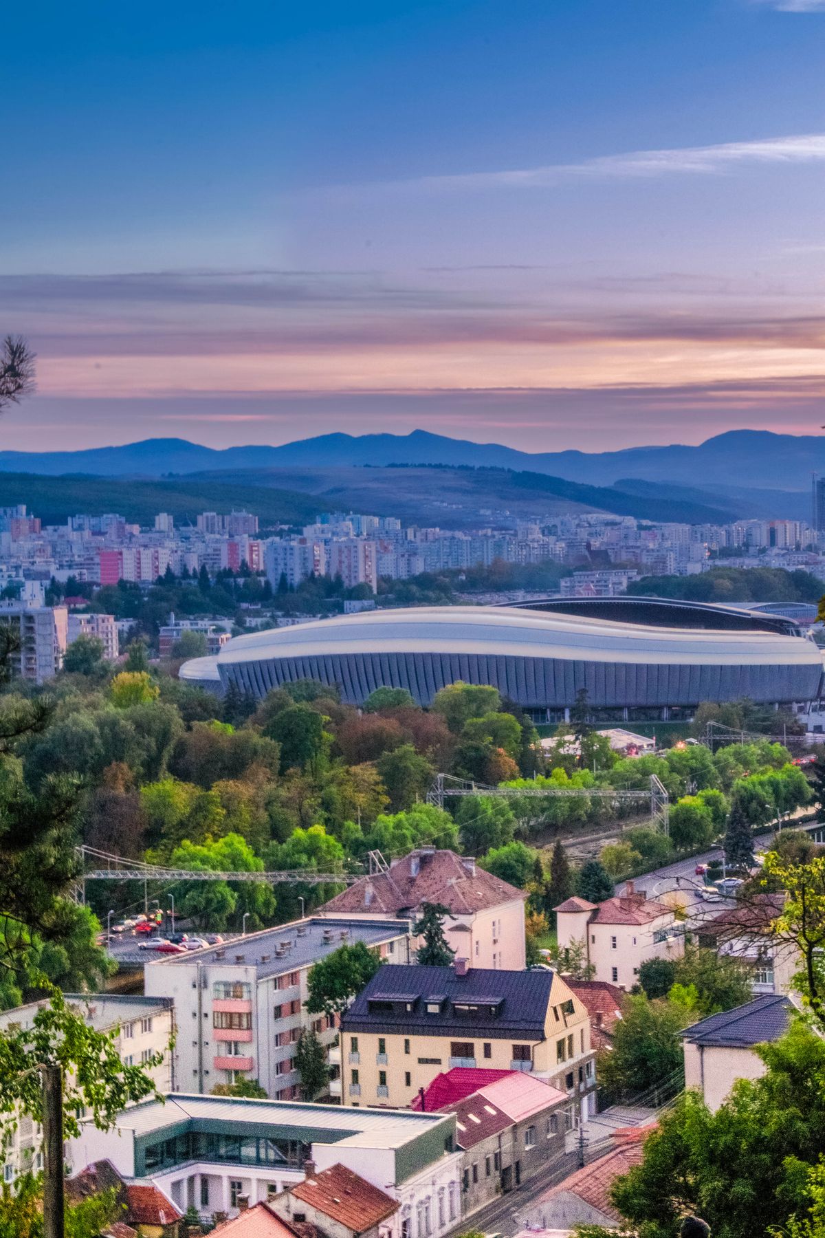 Cluj-Napoca - vedere aeriană cu stadionul, verdeață și dealuri la apus