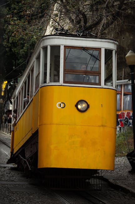 Discover the charm of Lisbon with this iconic yellow tram on a cobblestone street