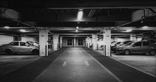 Free Black and white photo of an underground parking lot with cars and strong contrast lighting. Stock Photo